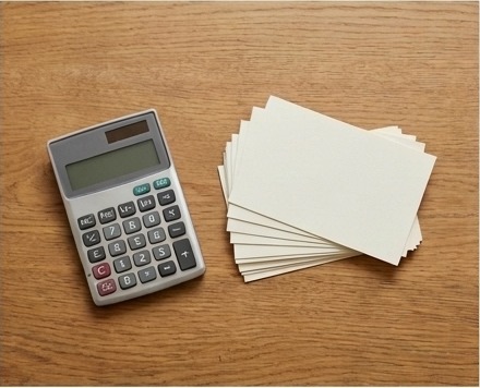 AI-generated editorial illustration of calculator beside blank project cards