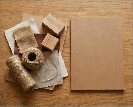 AI-generated editorial illustration of original craft materials beside blank workshop notebook