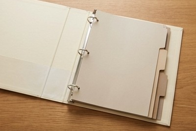 AI-generated editorial illustration: open blank binder with neutral dividers.