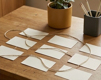 AI-generated editorial illustration: blank paper cards connected by loose cord.